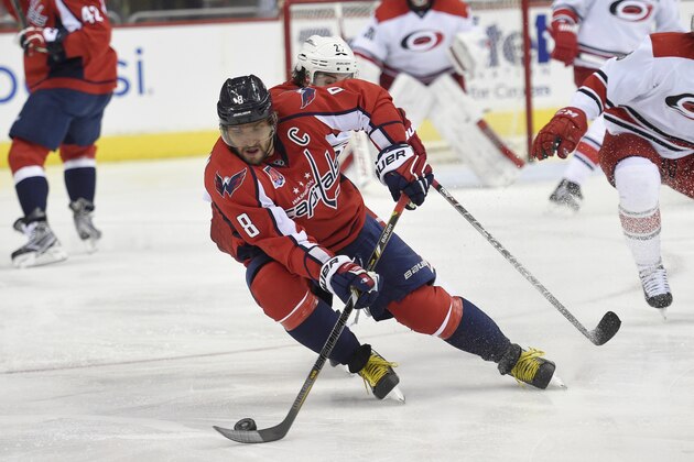 Washington Capitals left wing Alex Ovechkin (8), of Russia, skates with the puck against Carolina Hurricanes defenseman Justin Faulk (27) during the second period of an NHL hockey game, Tuesday, March 31, 2015, in Washington. (AP Photo/Nick Wass)
