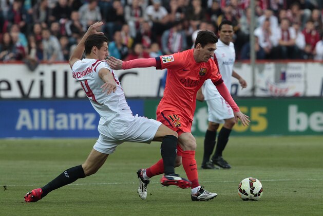 Barcelona's Lionel Messi, right, and Sevilla's Grzegorz Krychowiak, left, vie for the ball during their La Liga soccer match at the Ramon Sanchez Pizjuan stadium, in Seville, Spain on Saturday, April 11, 2015. (AP Photo/Angel Fernandez)