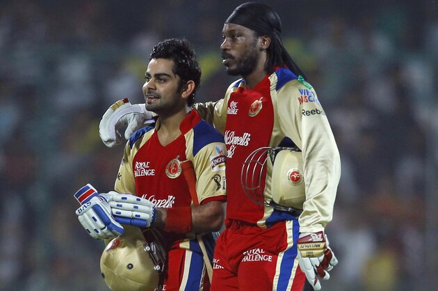 Chris Gayle, right, and Virat Kohli of Royal Challengers Bangalore walk back after their unbeaten 204 run second wicket partnership during their IPL cricket match against Delhi Daredevils, in New Delhi, India, Thursday, May 17, 2012. (AP Photo/ Saurabh Das)