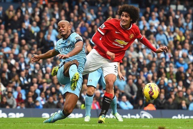 MANCHESTER, ENGLAND - NOVEMBER 02:  Vincent Kompany of Manchester City and Marouane Fellaini of Manchester United battle for the ball during the Barclays Premier League match between Manchester City and Manchester United at Etihad Stadium on November 2, 2014 in Manchester, England.  (Photo by Laurence Griffiths/Getty Images)