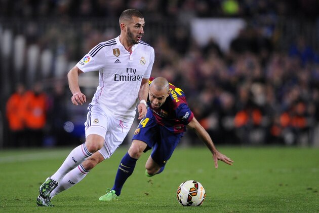 Real Madrid's Karim Benzema, left, takes the ball past Barcelona's Javier Mascherano during a Spanish La Liga soccer match between FC Barcelona and Real Madrid at Camp Nou stadium, in Barcelona, Spain, Sunday, March 22, 2015. (AP Photo/Manu Fernandez)