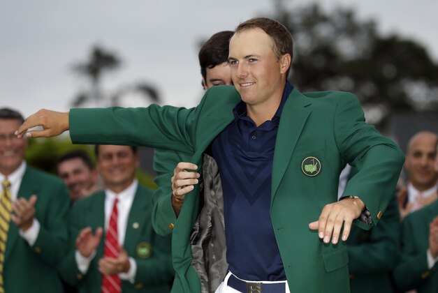 Bubba Watson helps Jordan Spieth put on his green jacket after winning the Masters golf tournament Sunday, April 12, 2015, in Augusta, Ga. (AP Photo/David J. Phillip)