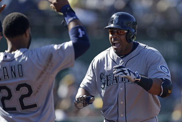 Seattle Mariners' Nelson Cruz, right, celebrates with Robinson Cano (22) after Cruz hit the game-winning home run off Oakland Athletics' Tyler Clippard in the tenth inning of a baseball game Sunday, April 12, 2015, in Oakland, Calif. Seattle won the game, 8-7. (AP Photo/Ben Margot)