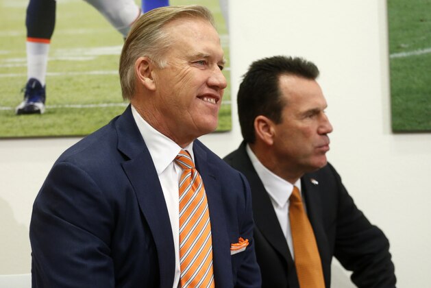 John Elway, left, Denver Broncos general manager and executive vice president of football operations, smiles before introducing Gary Kubiak, right, as the new head coach of the Broncos during am NFL football news conference, Tuesday, Jan. 20, 2015, in Englewood, Colo. (AP Photo/Jack Dempsey)