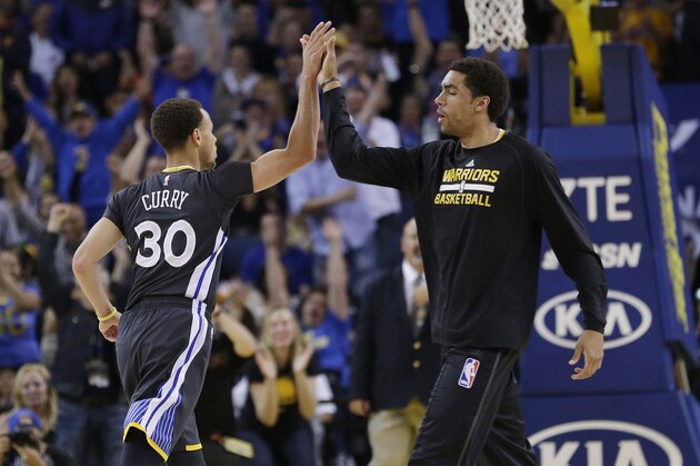 Golden State Warriors' Stephen Curry, left, gets a high-five rom James Michael McAdoo after Curry made a 3-point basket during the second half of an NBA basketball game against the Minnesota Timberwolves on Saturday, April 11, 2015, in Oakland, Calif. The Warriors won 110-101. (AP Photo/Marcio Jose Sanchez)