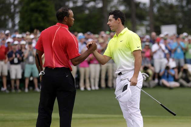 Tiger Woods, left, shakes hands with Rory McIlroy, of Northern Ireland, on the 18th hole during the fourth round of the Masters golf tournament Sunday, April 12, 2015, in Augusta, Ga. (AP Photo/David J. Phillip)