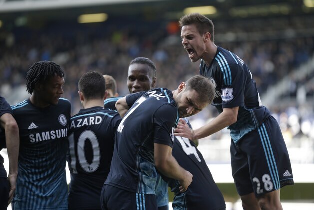 Chelsea's Branislav Ivanovic, center, turns away as he celebrates in front of the home supporters after his teammate Cesc Fabregas, second right obscured, scored during the English Premier League soccer match between QPR and Chelsea at Loftus Road stadium in London, Sunday, April 12, 2015. (AP Photo/Matt Dunham)