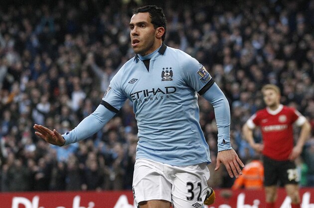 Manchester City's Carlos Tevez celebrates after scoring against Barnsley during their English FA Cup quarterfinal soccer match at The City of Manchester Stadium, Manchester, England, Saturday, March 9, 2013. (AP Photo/Jon Super)