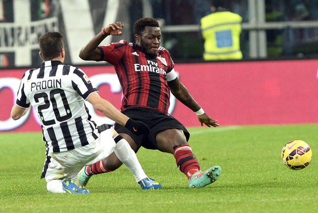 AC Milan' Sulley Muntari, right, is challenged by Juventus' Simone Padoin during a Serie A soccer match at the Juventus stadium, in Turin, Italy, Sunday, Feb. 7, 2015. (AP Photo/Massimo Pinca)