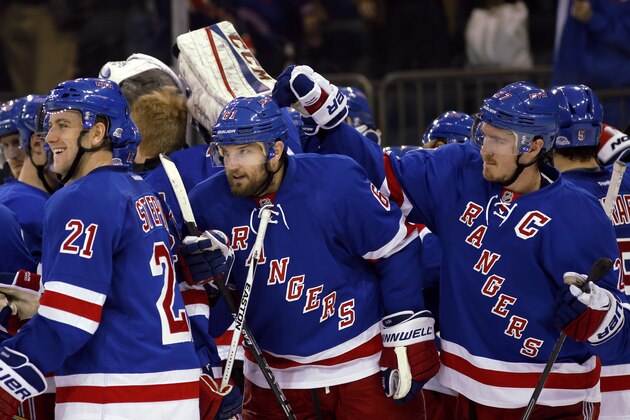 New York Rangers center Dominic Moore, far left, center Derek Stepan (21), left wing Rick Nash (61) and defenseman Ryan McDonagh (27) celebrate on the ice after defeating the Columbus Blue Jackets in overtime of an NHL hockey game at Madison Square Garden in New York, Sunday, Feb. 22, 2015.  The Rangers defeated the Blue Jackets 4-3 in a shootout on Rick Nash's goal. (AP Photo/Kathy Willens)