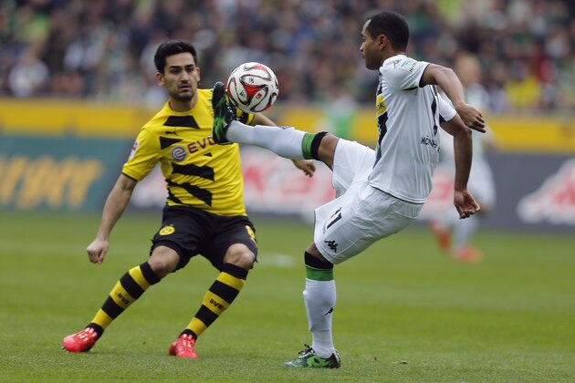 Dortmund's Ilkay Gundogan, left, and Moenchengladbach's Raffael from Brazil challenge for the ball during the German first division Bundesliga soccer match between Borussia Moenchengladbach and Borussia Dortmund in Moenchengladbach, Germany, Saturday, April 11, 2015. (AP Photo/Frank Augstein)