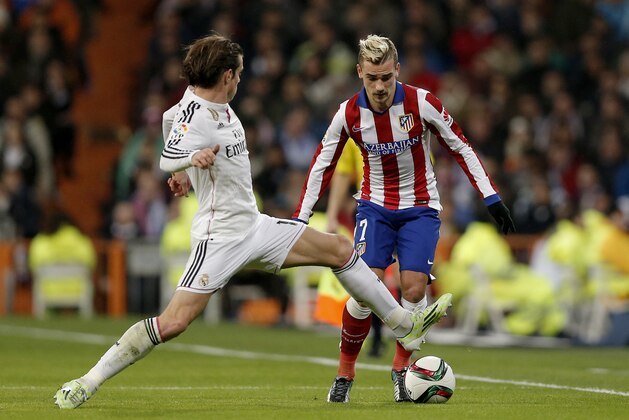 Real Madrid's Gareth Bale from Britain, left, duels for the ball with Atletico de Madrid Antoine Griezmann during a King's Cup soccer match between Atletico de Madrid and Real Madrid, at the Santiago Bernabeu stadium in Madrid, Spain, Thursday, Jan. 15, 2015. (AP Photo/Daniel Ochoa de Olza)