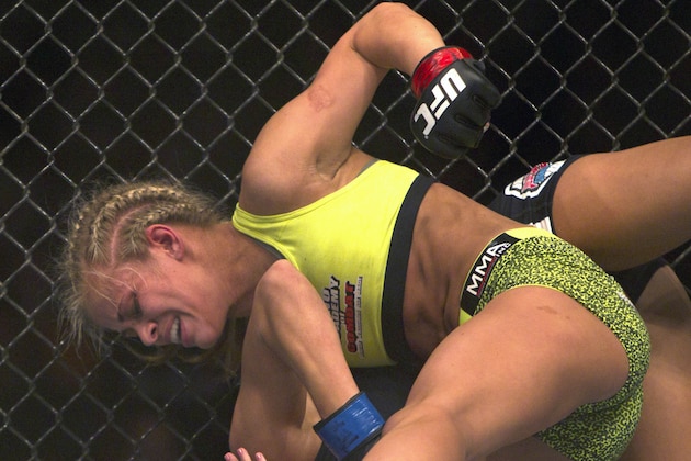 Paige Vanzant, top, throws a punch against Kailin Curren in a women's strawweight mixed martial arts bout during the UFC Fight Night at the Frank Erwin Center in Austin, Texas, Saturday, Nov. 22, 2014. (AP Photo/Michael Thomas)