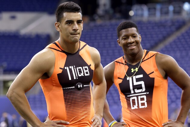Oregon quarterback Marcus Mariota (11) and Florida State quarterback Jameis Winston (15) wait to run a drill at the NFL football scouting combine in Indianapolis, Saturday, Feb. 21, 2015. (AP Photo/David J. Phillip)