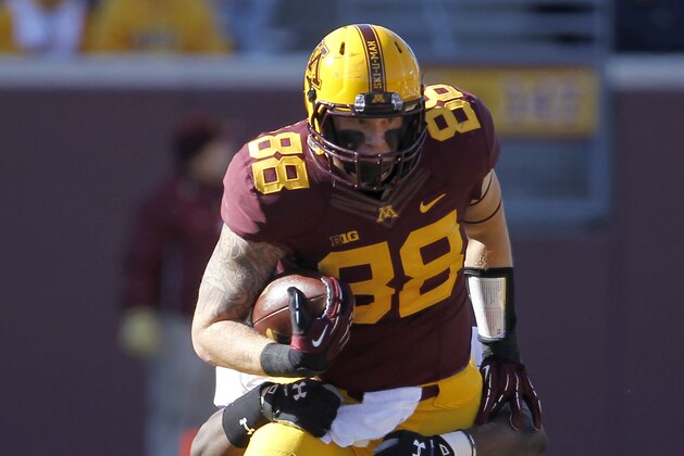Minnesota tight end Maxx Williams (88) drags along Northwestern defensive lineman Xavier Washington on a gain during the first quarter of an NCAA college football game in Minneapolis Saturday, Oct. 11, 2014. (AP Photo/Ann Heisenfelt)