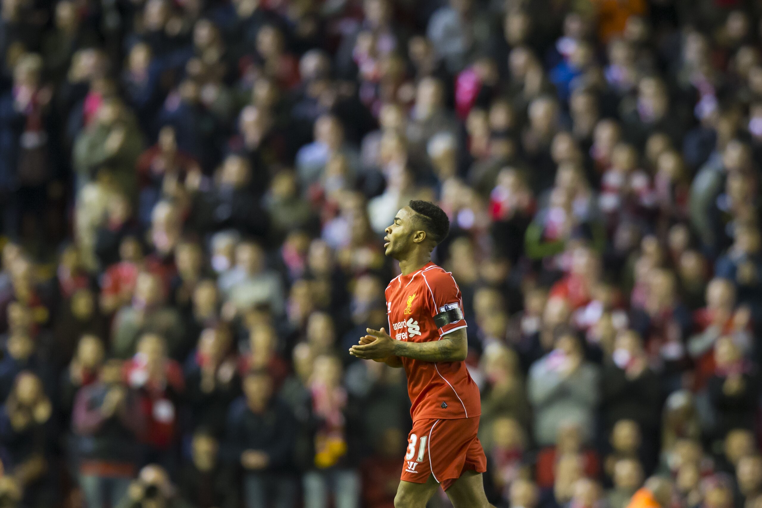 Liverpool's Raheem Sterling applauds supporters after being substituted during his team's English Premier League soccer match between Liverpool and Newcastle at Anfield Stadium, Liverpool, England, Monday, April 13, 2015. (AP Photo/Jon Super)