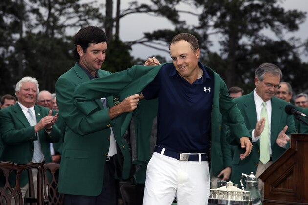Bubba Watson helps Jordan Spieth put on his green jacket after winning the Masters golf tournament Sunday, April 12, 2015, in Augusta, Ga. (AP Photo/Matt Slocum)