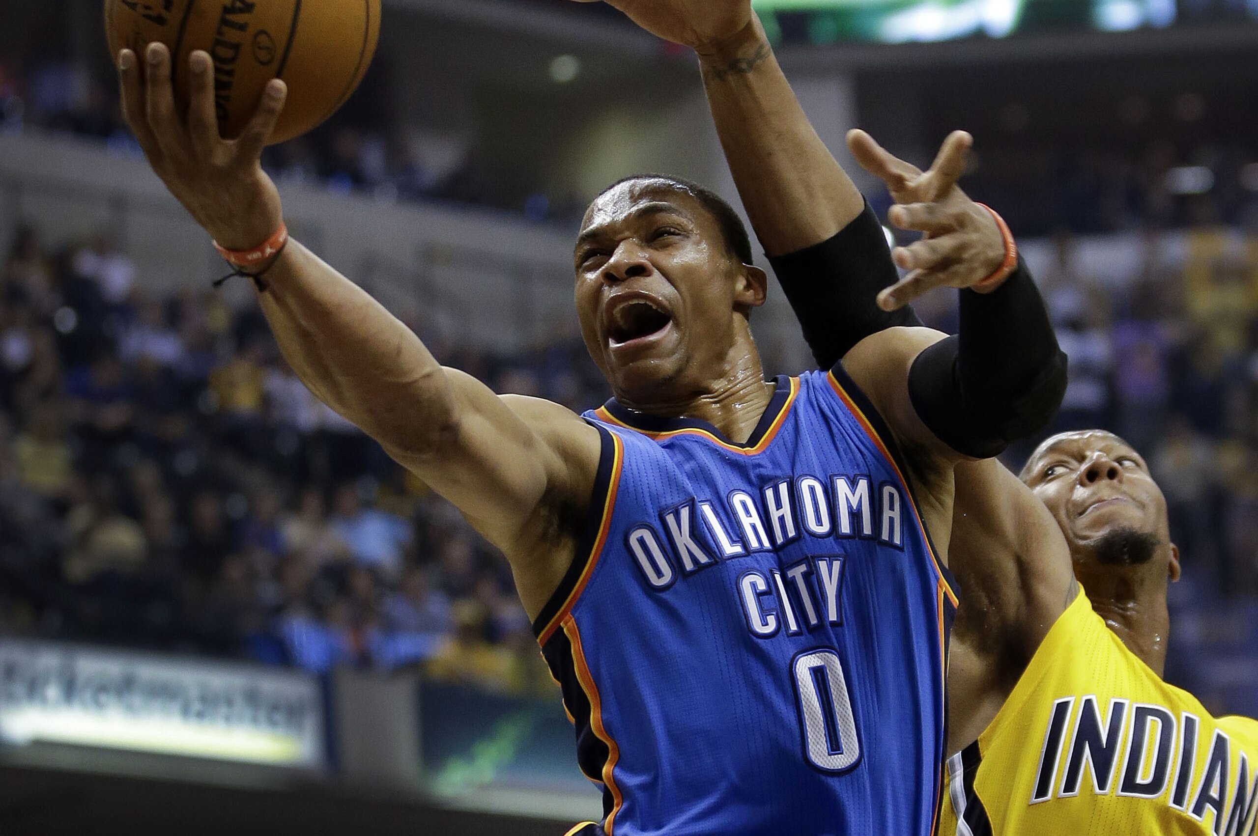 Russell Westbrook, del Thunder de Oklahoma City, salta para encestar frente a David West, de los Pacers de Indiana, en el partido del domingo 12 de abril de 2015 (AP Foto/AJ Mast)