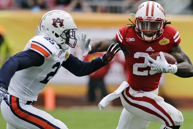 Wisconsin running back Melvin Gordon (25) stiff arms Auburn defensive back Johnathan Ford (23) on a run during the second quarter of the Outback Bowl NCAA college football game, Thursday, Jan. 1, 2015, in Tampa, Fla. (AP Photo/Chris O'Meara)