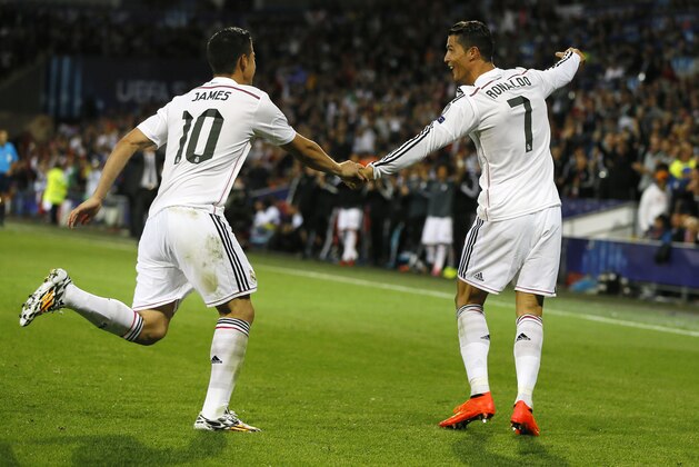 Real Madrid’s Cristiano Ronaldo, right, celebrates with James Rodriguez after scoring the second goal during the UEFA Super Cup soccer match between Read Madrid and Sevilla at Cardiff City Stadium in Wales Tuesday, Aug. 12, 2014. (AP Photo/Kirsty Wigglesworth)