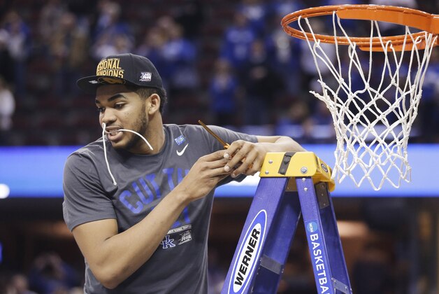 Kentucky's Karl-Anthony Towns holds part of the net in his teeth after Kentucky's 68-66 win over Notre Dame in a college basketball game in the NCAA men's tournament regional finals, Saturday, March 28, 2015, in Cleveland. (AP Photo/Tony Dejak)
