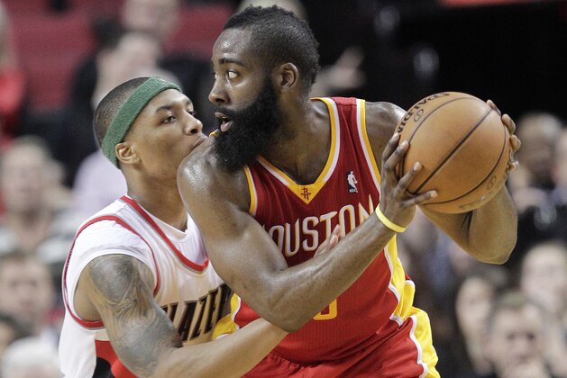 Houston Rockets guard James Harden, right, looks for a move to the basket as Portland Trail Blazers guard Damian Lillard defends during the second half of an NBA basketball game in Portland, Ore., Friday, April 5, 2013.  Harden scored 33 points and pulled in 7 rebounds as the Rockets won 116-98. (AP Photo/Don Ryan)