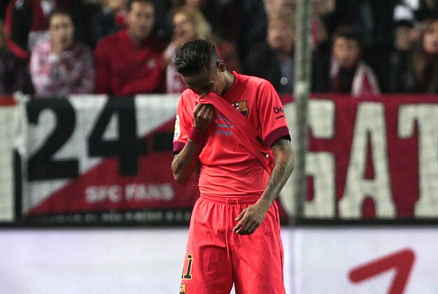 Barcelona's Neymar da Silva from Brazil wipes his face during the La Liga soccer match against Sevilla at the Ramon Sanchez Pizjuan stadium, in Seville, Spain on Saturday, April 11, 2015. (AP Photo/Angel Fernandez)