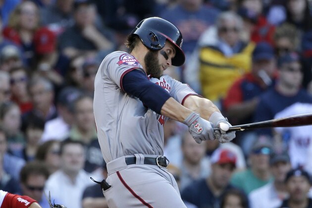Washington Nationals' Bryce Harper, right, swings at a pitch as Boston Red Sox catcher Sandy Leon, left, looks on in the fourth inning of a baseball game, Monday, April 13, 2015, in Boston. (AP Photo/Steven Senne)