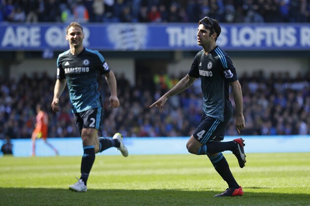 Chelsea's Cesc Fabregas, right, celebrates after scoring the opening goal during the English Premier League soccer match between QPR and Chelsea at Loftus Road stadium in London, Sunday, April 12, 2015. (AP Photo/Matt Dunham)