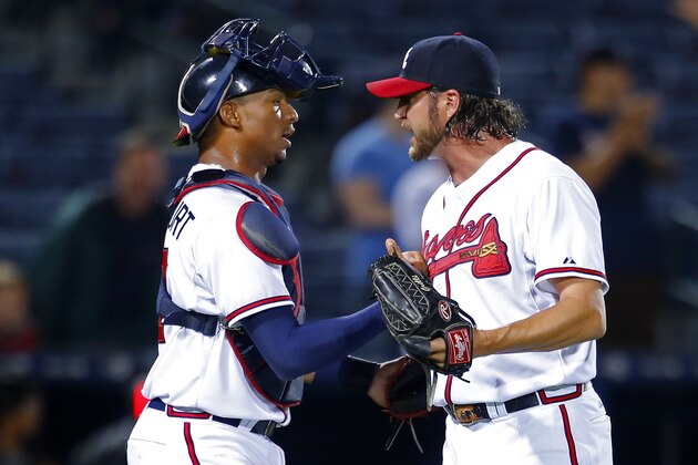 Atlanta Braves relief pitcher Jason Grilli, right, celebrates with catcher Christian Bethancourt at the conclusion of a baseball game against the Miami Marlins, Monday, April 13, 2015, in Atlanta. The Braves won 3-2. (AP Photo/Todd Kirkland)
