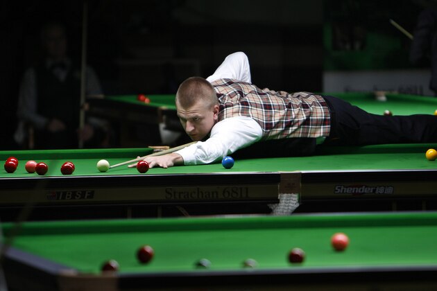 Poland's Marcin Nitschke lies on the table to play a shot during a round robin league match against Switzerland's Pascal Camenzind at the International Billiards and Snooker Federation (IBSF) World Snooker Championship in Bangalore, India, Monday, Nov. 28, 2011. The six-day event which started Monday have participants from 41 countries. (AP Photo/Aijaz Rahi)