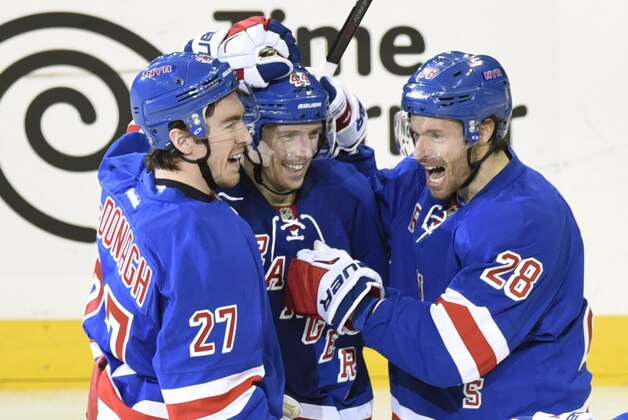 New York Rangers' Matt Hunwick, center, celebrates his goal with Ryan McDonagh, left, and Dominic Moore during the third period of an NHL hockey game against the Florida Panthers, Sunday, March 15, 2015, at Madison Square Garden in New York. The Rangers won 2-1. (AP Photo/Bill Kostroun)