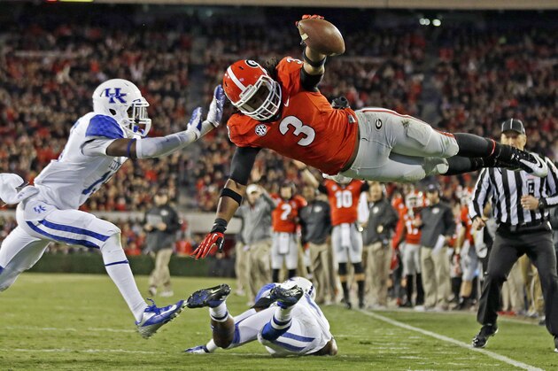 FILE - In this Nov. 23, 2013, file photo, Georgia running back Todd Gurley (3) dives into the end zone for a touchdown as Kentucky cornerback Jaleel Hytchye, left, defends in the first half of an NCAA college football game in Athens, Ga. Georgia coach Mark Richt says junior running back Gurley has informed him that he plans to enter the NFL draft. Richt made the announcement after practice Friday, Dec. 26, 2014, for the Belk Bowl. (AP Photo/John Bazemore, File)