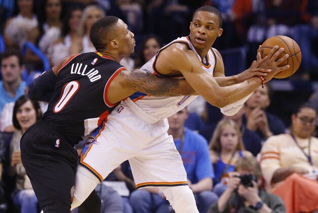Portland Trail Blazers guard Damian Lillard (0) reaches for the ball held by Oklahoma City Thunder guard Russell Westbrook (0) during the second quarter of an NBA basketball game in Oklahoma City, Monday, April 13, 2015. (AP Photo/Sue Ogrocki)
