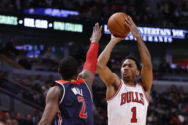 Chicago Bulls guard Derrick Rose (1) shoots a three point shot over Washington Wizards guard John Wall during the second half of an NBA basketball game Wednesday, Jan. 14, 2015, in Chicago. The Wizards won 105-99. (AP Photo/Charles Rex Arbogast)