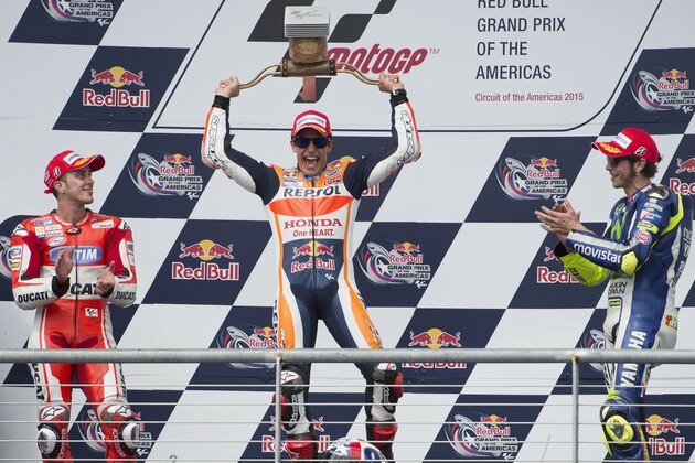 Marc Marquez, center, of Spain, center, celebrates his win with second position finisher Andrea Dovizioso, left, of Italy, and third position finisher Valentino Rossi, of Italy, after the MotoGP Grand Prix of the Americas motorcycle race, Sunday, April 12, 2015, at the Circuit of the Americas in Austin, Texas. (AP Photo/Darren Abate)