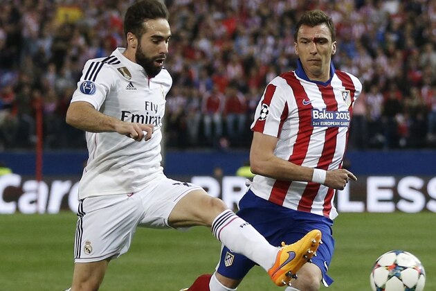 Real Madrid's Daniel Carvajal, challenges Atletico's Mario Mandzukic, right, during the Champions League quarterfinal, first leg soccer match between Atletico de Madrid and Real Madrid at the Vicente Calderon stadium in Madrid, Spain, Tuesday, April 14, 2015. (AP Photo/Daniel Ochoa de Olza)