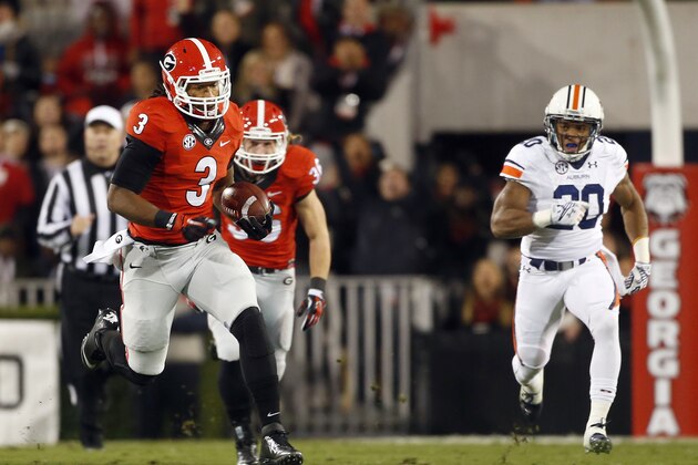 Georgia's Todd Gurley (3) returns a kickoff for a touchdown as Auburn running back Corey Grant (20) defends in the first half of an NCAA college football game Saturday, Nov. 15, 2014, in Athens, Ga. The touchdown was called back due to a holding penalty. (AP Photo/John Bazemore)