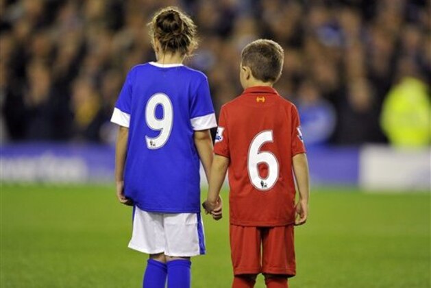 Two Everton mascots, one wearing a Liverpool FC kit stand in the centre circle in a minute's applause in recognition of the 96 Liverpool fans that died at Hillsborough disaster during their English Premier League soccer match at Goodison Park in Liverpool, England, Monday Sept. 17, 2012. (AP Photo/Clint Hughes)