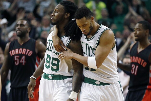 Boston Celtics' Jae Crowder (99) celebrates his basket with teammate Evan Turner in front of Toronto Raptors' Patrick Patterson (54) and Terrence Ross (31) during the final seconds of the fourth quarter of an NBA basketball game in Boston, Tuesday, April 14, 2015. The Celtics won 95-93. (AP Photo/Michael Dwyer)