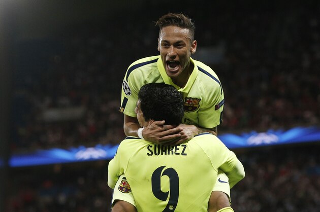 Barcelona's Luis Suarez, rear, celebrates with Neymar after Suarez scored his team's third goal during the quarterfinal first leg Champions League soccer match between Paris Saint Germain and Barcelona at the Parc des Princes stadium in Paris, France, Wednesday, April 15, 2015. (AP Photo/Christophe Ena)