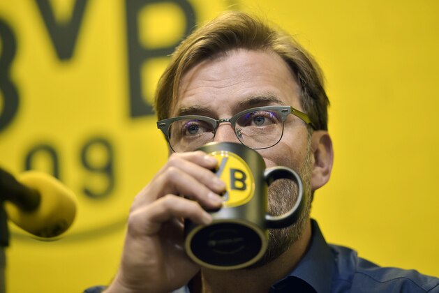 Borussia Dortmund's head coach Juergen Klopp drinks from a cup with the logo of the soccer club at a press conference in the Dortmund stadium, Wednesday, April 15, 2015. Klopp will leave Borussia Dortmund at the end of this season after seven years in charge, stepping down after a dismal season for the club. (AP Photo/Martin Meissner)