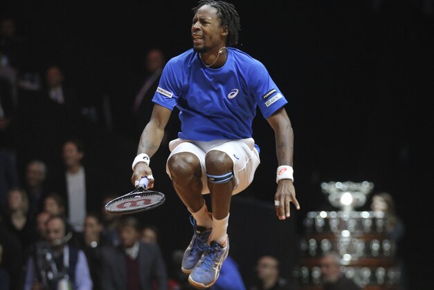 France's Gael Monfils jumps after a winning point as he plays Switzerland's Roger Federer during the Davis Cup final in Lille, northern France, Friday, Nov.21, 2014. (AP Photo/Christophe Ena)