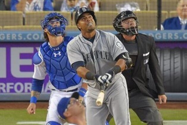 Seattle Mariners' Nelson Cruz, top center, watches his home run, along with Los Angeles Dodgers pitcher David Huff, front, and catcher Yasmani Grandal, left, and home plate umpire Greg Gibson during the first inning of a baseball game, Tuesday, April 14, 2015, in Los Angeles. (AP Photo/Mark J. Terrill)