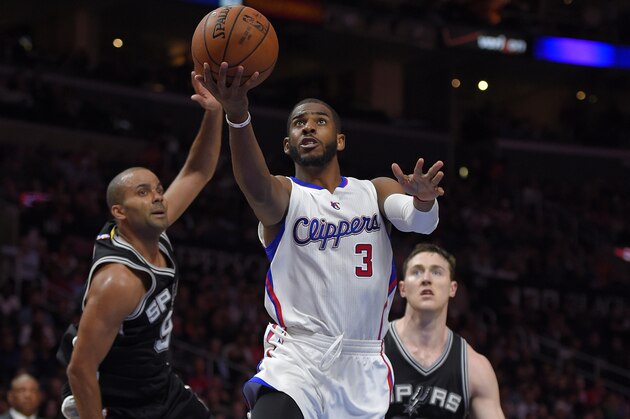 Los Angeles Clippers guard Chris Paul, center, goes up for a shot as San Antonio Spurs guard Tony Parker, left, of France, and center Aron Baynes, of Australia, defends during the second half of an NBA basketball game, Thursday, Feb. 19, 2015, in Los Angeles. The Clippers won 119-115. (AP Photo/Mark J. Terrill)
