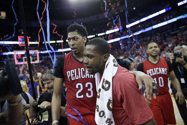New Orleans Pelicans forward Anthony Davis, left, hugs guard Toney Douglas after their NBA basketball game against the San Antonio Spurs in New Orleans, Wednesday, April 15, 2015. The Pelicans won 108-103 to lock up the final playoff slot in the Western Conference. (AP Photo/Gerald Herbert)