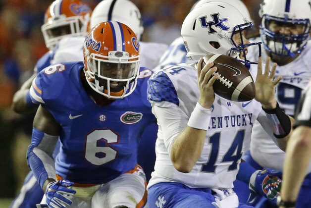 Florida defensive lineman Dante Fowler, Jr. (6) puts pressure on Kentucky quarterback Patrick Towles (14) during the first half of an NCAA college football game in Gainesville, Fla., Saturday, Sept. 13, 2014. (AP Photo/John Raoux)