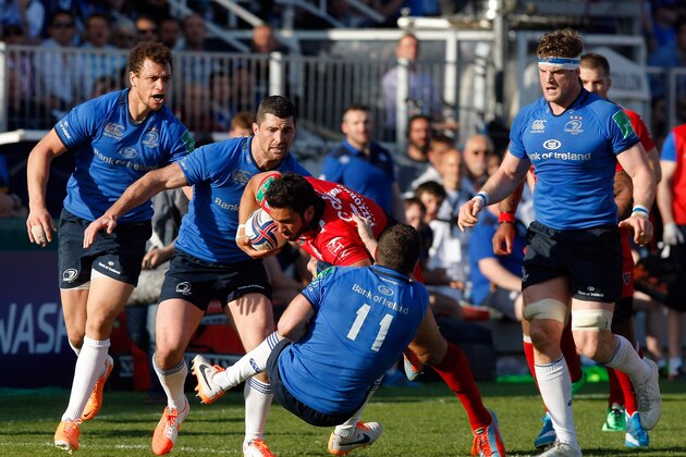Toulon's French inside centre Maxime Mermoz, center,  is tackled by Leinster's Irish Wing Dave Kearney, during their Heineken European Cup quarter final rugby match, at the Mayol stadium, in Toulon, southern France, Sunday, April 6, 2014. (AP Photo/Claude Paris)