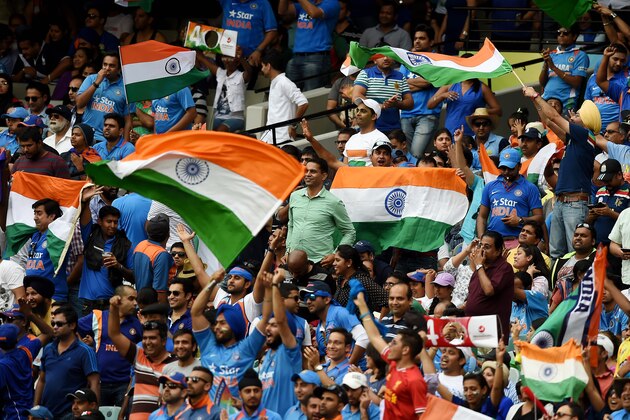 Indian fans wave their flags as they cheer their team during their Cricket World Cup quarterfinal match against Bangladesh in Melbourne, Australia, Thursday, March 19, 2015. (AP Photo/Andy Brownbill)