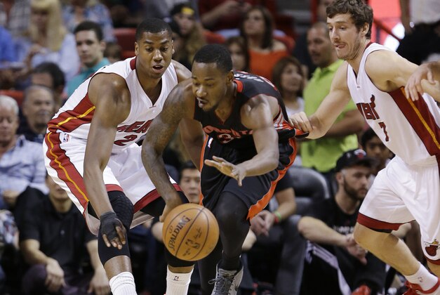 Toronto Raptors forward Terrence Ross (31), center, Miami Heat center Hassan Whiteside, left, and guard Goran Dragic (7) of Slovenia, battle for a loose ball during the first half of an NBA basketball game, Saturday, April 11, 2015, in Miami. The Raptors defeated the Heat 107-104. (AP Photo/Wilfredo Lee)
